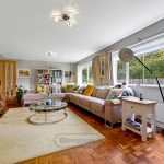 Spacious living room with large sofa, bookshelves, fireplace.