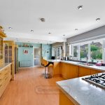 Spacious modern kitchen with wooden cabinets and island.