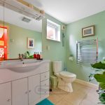 Modern bathroom with green walls and a large mirror.