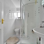 Modern white bathroom with shower and sink.