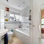 Modern bathroom with bathtub and white tiles