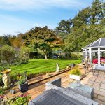Sunny garden with patio and conservatory