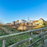 Modern houses with wooden walkway in foreground.