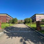Office buildings with brick exterior and green surroundings.