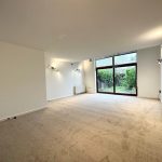 Spacious lounge with large windows and garden view.