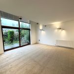 Spacious living room with large window and modern lighting.