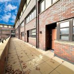 Modern brick building with pathway and fallen leaves