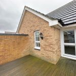 Brick-walled patio with wooden decking.