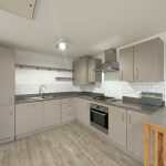 Modern kitchen with grey cabinets and appliances.