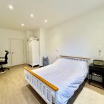 Minimalist bedroom with workspace and wardrobe.