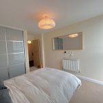 Contemporary bedroom with soft lighting and minimalist decor.