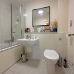 Modern bathroom with sink, toilet, and bathtub.