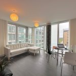 Modern apartment living room with large windows.