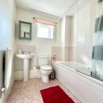 Bright bathroom with bathtub, sink, and toilet.