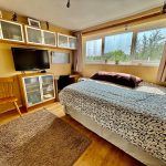 Bright bedroom with TV and large windows.