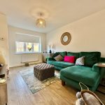 Stylish living room with green sofa and decor.