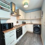 Modern kitchen with appliances and spice rack.