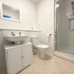 Modern bathroom with shower, sink, and toilet.