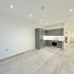 Modern kitchen in spacious grey laminate flooring apartment.