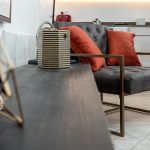 Modern lounge chair with red cushions in living room.