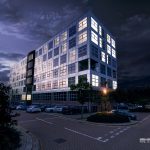 Night view of illuminated office building and car park.