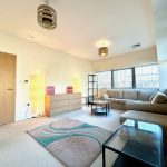Modern living room with beige sofa and ambient lighting.