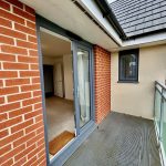 Modern balcony with sliding door and street view.
