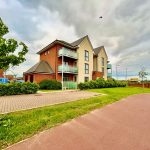 Modern residential building with green surroundings.