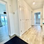 Spacious modern hallway with wooden flooring.