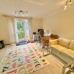 Family room with playmat, sofa, and desk area.