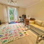 Bright lounge with play mat and garden view.