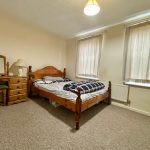 Cosy bedroom with wooden furniture and natural light.