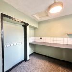 Empty room with green walls and tiled counter.