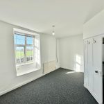 Bright empty room with sunny window and open door.