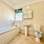 Modern bathroom with bathtub, toilet, and sink.