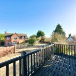 View of suburban houses from a wooden balcony.