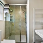Modern bathroom with shower and towel radiator.