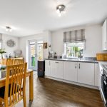 Modern kitchen with dining area and wooden floor.