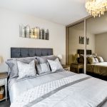 Modern bedroom with mirrored wardrobe and chandelier