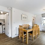 Modern dining room with wooden table and chairs.