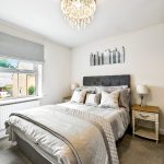 Modern bedroom with king-size bed and chandelier.