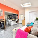 Modern kitchen and living area with skylight and decor.