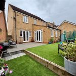 Brick house with patio and garden furniture.