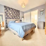 Cosy bedroom with blue accents and natural light.