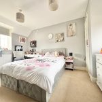 Cosy bedroom with grey and white furnishings.