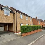 Modern brick terraced house with garage and driveway.