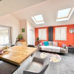 Modern kitchen-lounge with skylights and colourful decor.