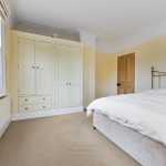 Bright bedroom with bed, window, and wardrobe.