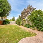 Spacious garden with greenery and pathway.