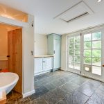 Bright kitchen with garden view and stone flooring.